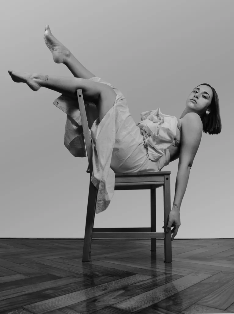 Leaning back on a chair, legs raised