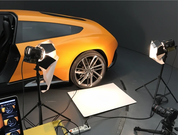 The car on set in the studio, softbox lights around it and the camera tethered to a tablet