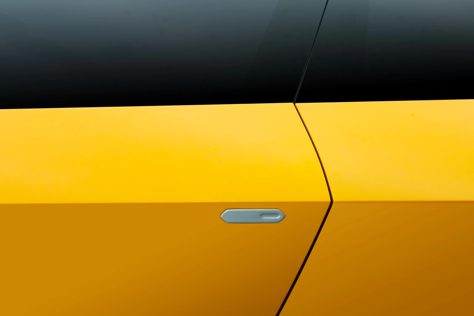 Flush door handle on the yellow door, below the dark glass