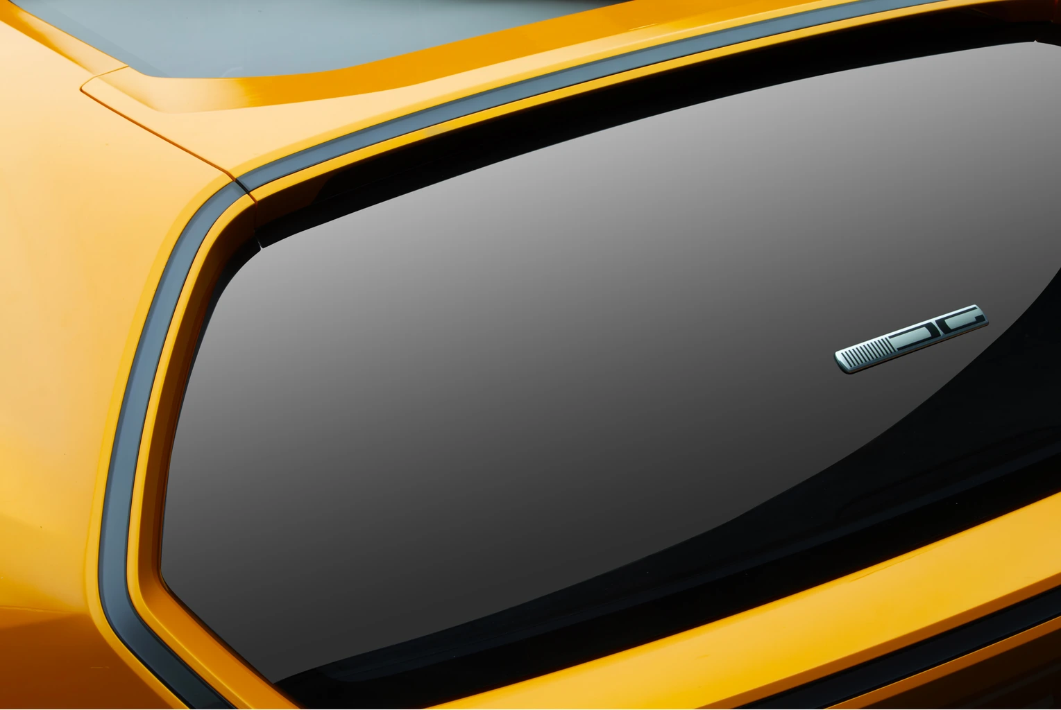 Rear quarter window in its black frame, with a small chrome badge