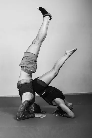 Two performers in a shared headstand with legs raised