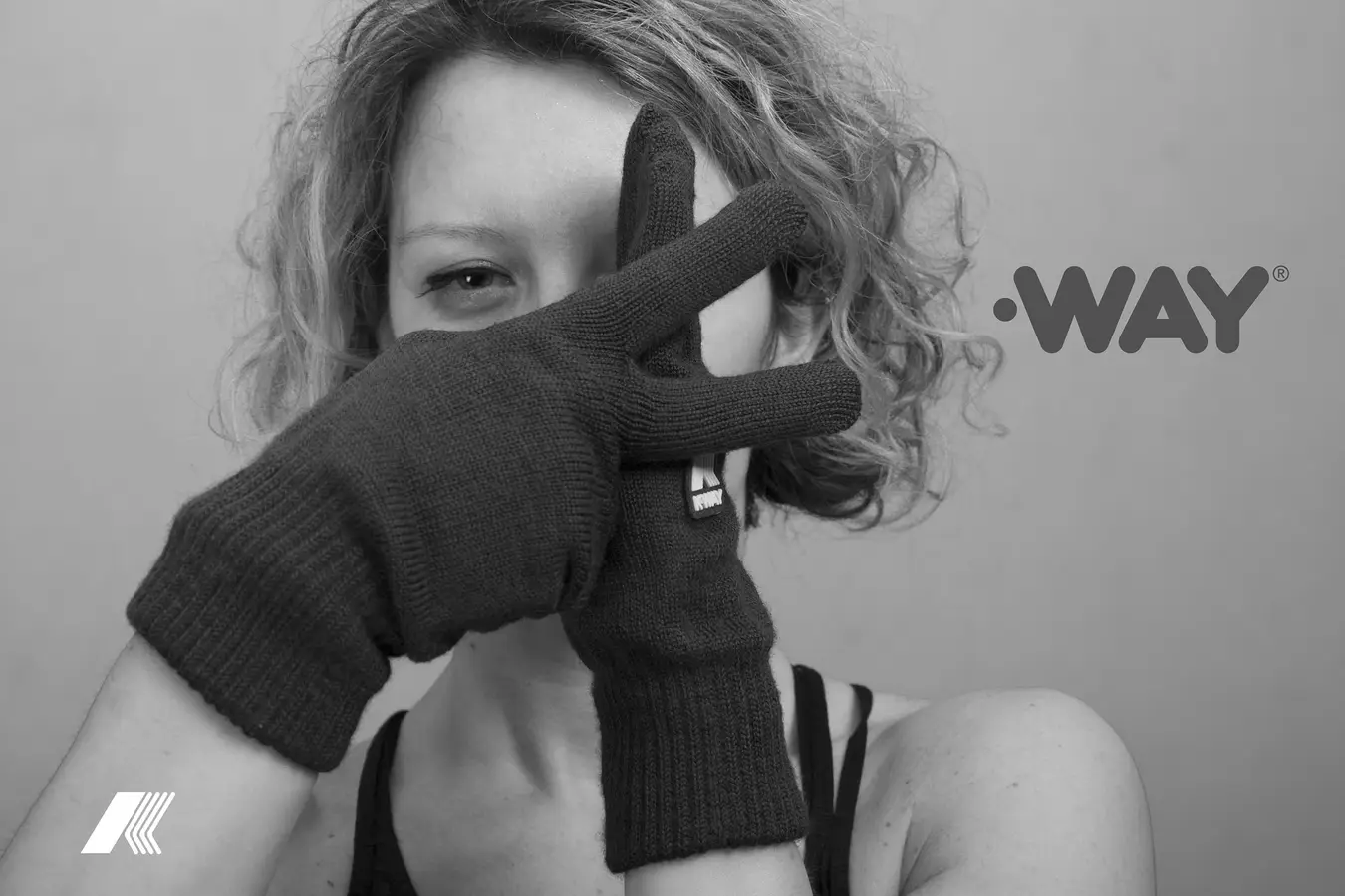 Gloved hands forming a K across a model's face
