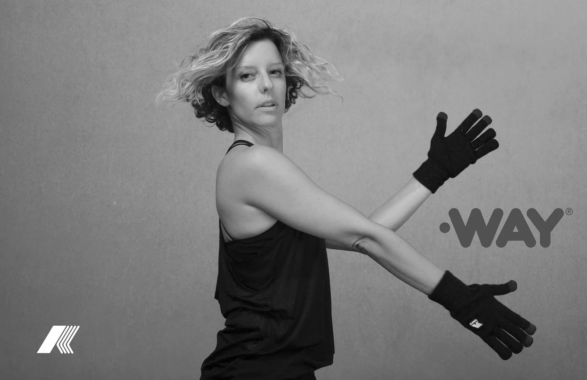 Model turning away, both arms outstretched in black K-WAY gloves